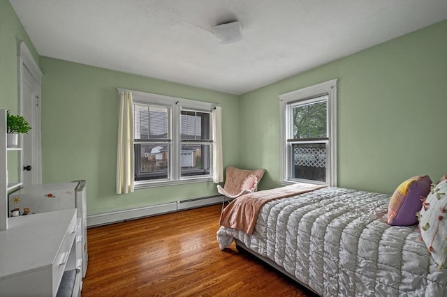 bedroom featuring wood finished floors and a baseboard radiator