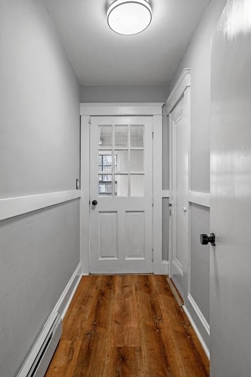 doorway featuring wood finished floors and baseboards