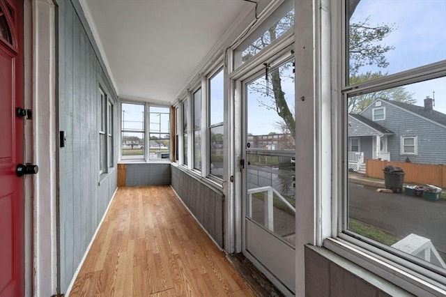 unfurnished sunroom featuring wood finished floors and plenty of natural light