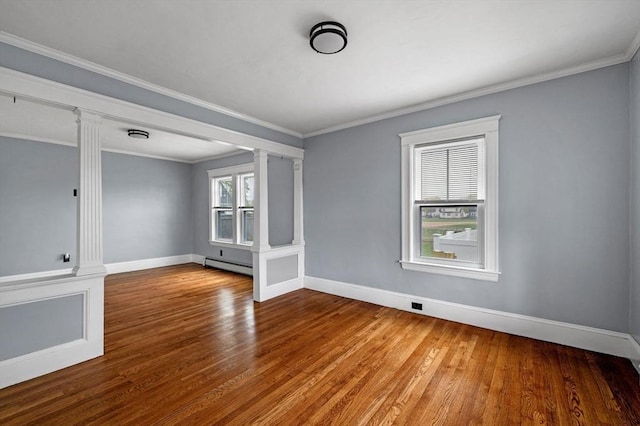 unfurnished room with a baseboard heating unit, decorative columns, wood finished floors, and baseboards