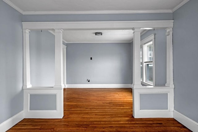 unfurnished room featuring ornamental molding, ornate columns, wood finished floors, and baseboards
