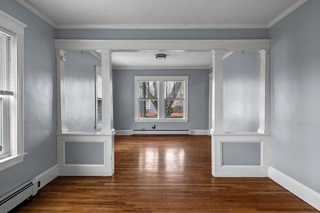 empty room featuring ornate columns, wood finished floors, and a baseboard heating unit