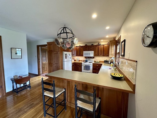 32 Machipscat Trl, West Tisbury, MA 02575 - kitchen with a peninsula, wood finished floors, a sink, white appliances, and light countertops
