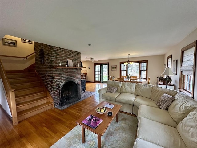 32 Machipscat Trl, West Tisbury, MA 02575 - living room featuring a fireplace, stairs, ceiling fan with notable chandelier, and wood finished floors