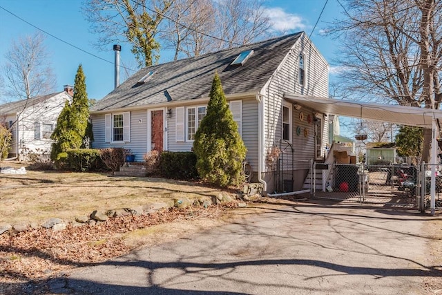 view of front of home featuring a carport, a gate, driveway, and a shingled roof