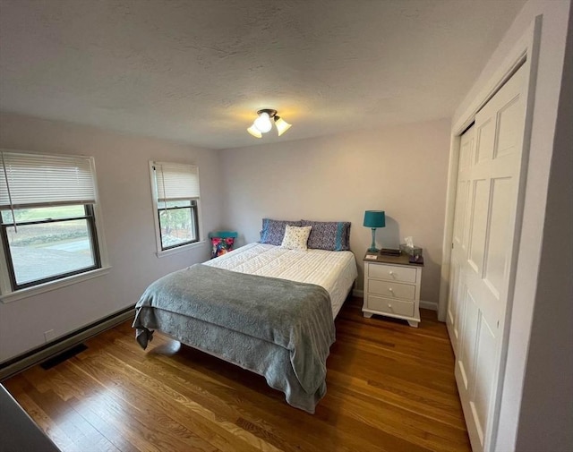 bedroom with baseboards, a closet, and wood finished floors
