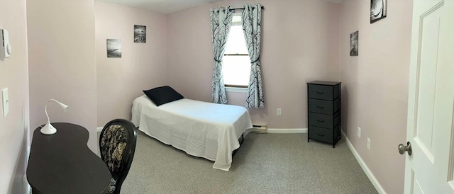 bedroom featuring baseboards, light carpet, and a baseboard heating unit