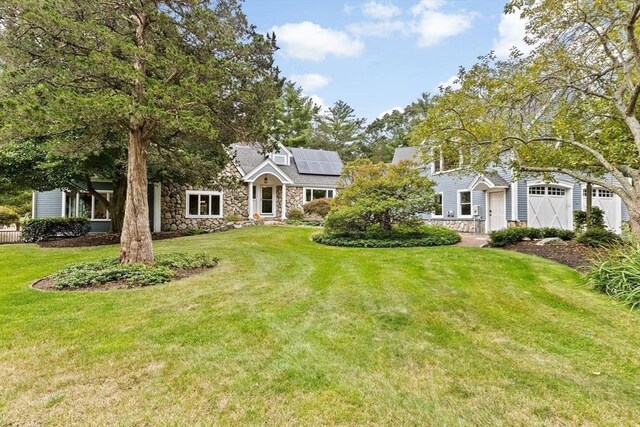 26 Mordecai Lincoln Rd, Scituate, MA 02066 - view of front of property featuring stone siding, solar panels, and a front lawn