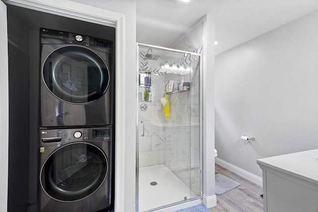 78 Conserve Ave, Westport, MA 02790 - bathroom featuring stacked washer / dryer, a shower stall, baseboards, wood finished floors, and toilet