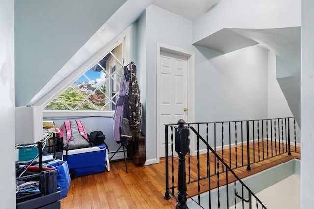 bonus room with wood-type flooring and a baseboard heating unit