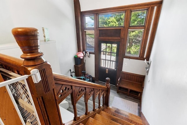 doorway with baseboards, wood finished floors, and stairway