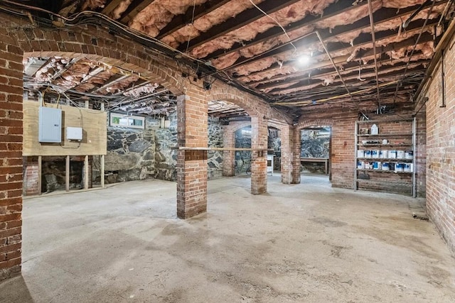 unfinished below grade area featuring brick wall and electric panel
