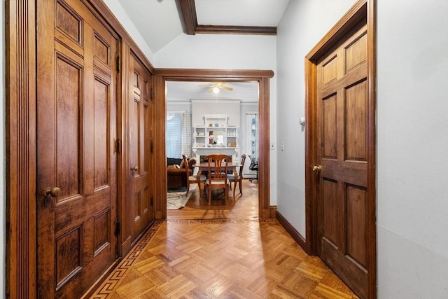 foyer entrance featuring baseboards, ornamental molding, ceiling fan, and vaulted ceiling