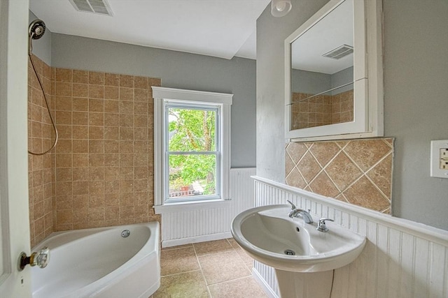 bathroom featuring wainscoting, tile patterned flooring, a sink, and bathing tub / shower combination