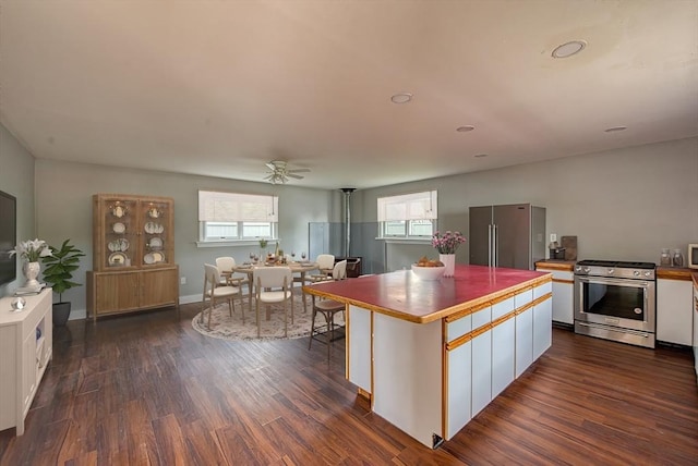 kitchen featuring appliances with stainless steel finishes, white cabinetry, plenty of natural light, and a center island