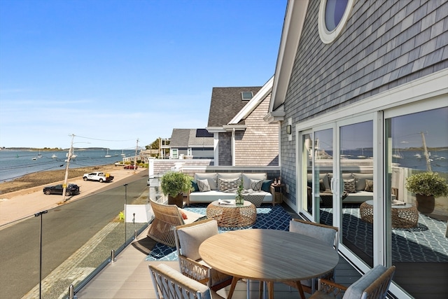 balcony featuring a water view and an outdoor hangout area