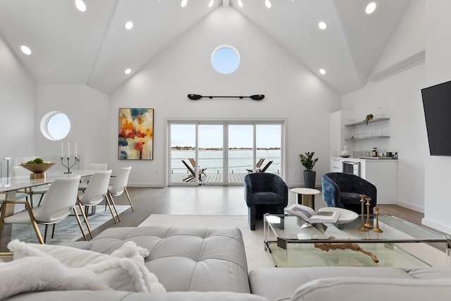 living room with light wood-type flooring and high vaulted ceiling