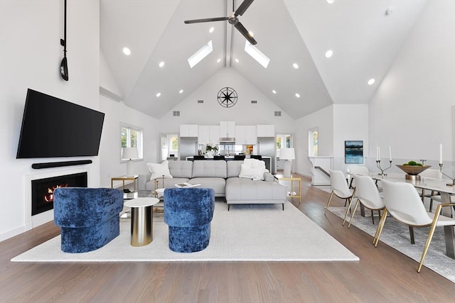 living room with ceiling fan, hardwood / wood-style floors, and high vaulted ceiling