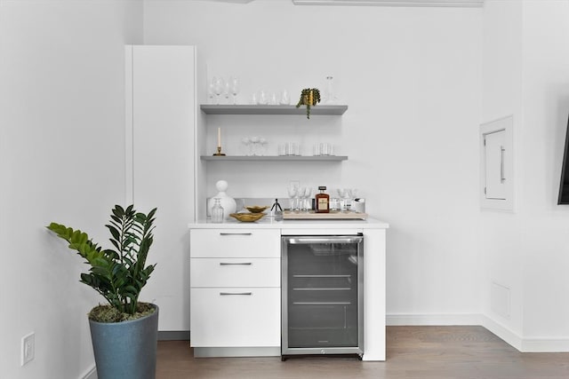 bar with wine cooler, white cabinetry, and dark hardwood / wood-style flooring