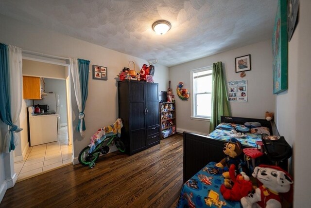 bedroom with a textured ceiling and light wood finished floors