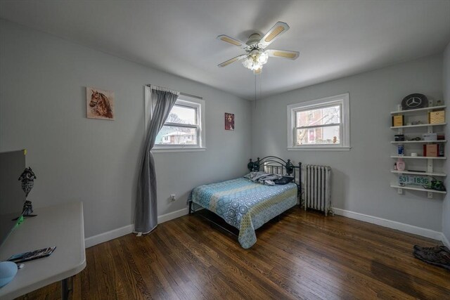 bedroom with baseboards, ceiling fan, wood finished floors, and radiator