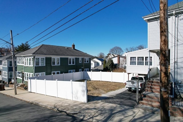 exterior space with driveway, fence, and a residential view