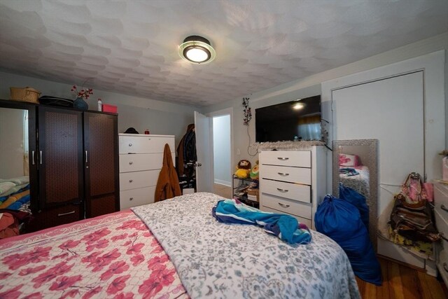 bedroom featuring a textured ceiling and wood finished floors