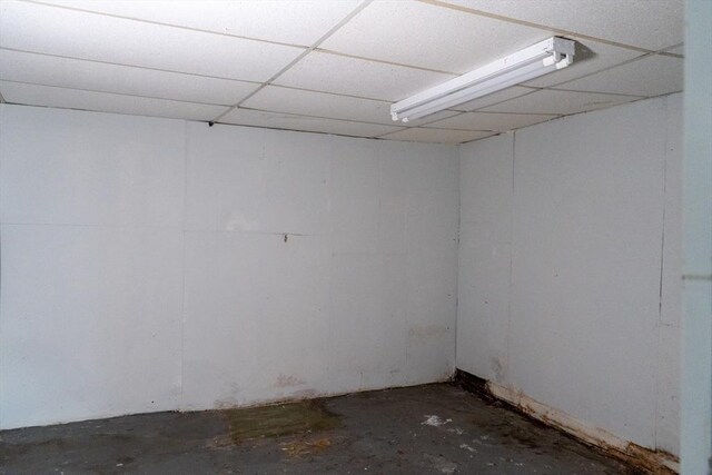 spare room featuring concrete flooring and a drop ceiling