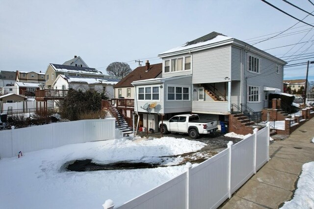 view of front facade featuring stairs, a fenced backyard, and a residential view