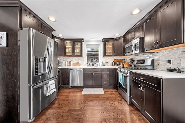 39 Madison St Unit 2, Somerville, MA 02143 - kitchen featuring stainless steel appliances, dark brown cabinets, tasteful backsplash, glass insert cabinets, and dark wood finished floors