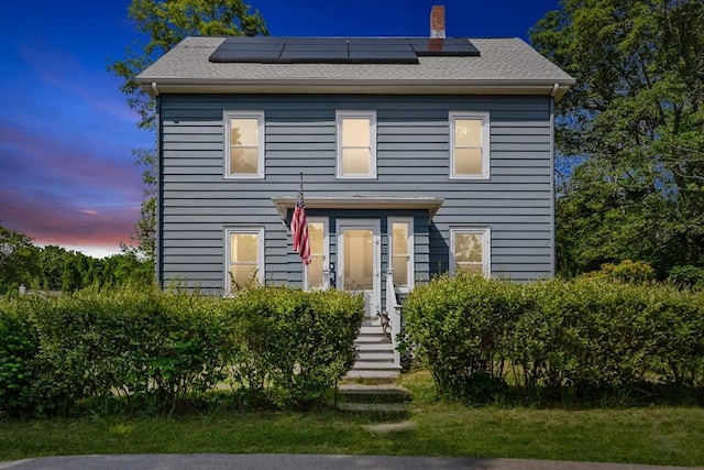 12 Russell St, Amesbury, MA 01913 - view of front of property with roof mounted solar panels and a chimney