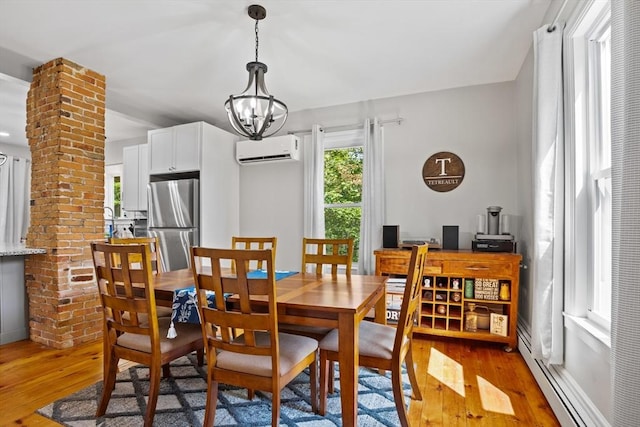 12 Russell St, Amesbury, MA 01913 - dining area featuring a wall mounted AC, light wood finished floors, a baseboard radiator, and a chandelier