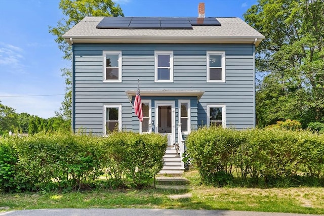 12 Russell St, Amesbury, MA 01913 - view of front facade featuring solar panels and a chimney