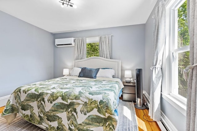 12 Russell St, Amesbury, MA 01913 - bedroom featuring a wall mounted AC, wood finished floors, and baseboard heating