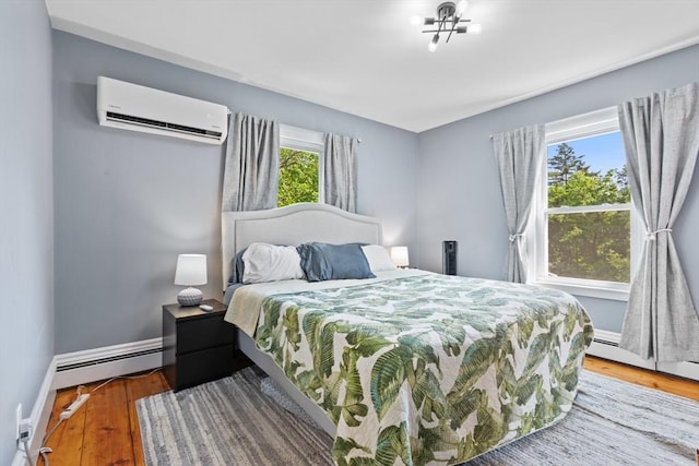 12 Russell St, Amesbury, MA 01913 - bedroom with a wall unit AC, wood finished floors, and a baseboard heating unit