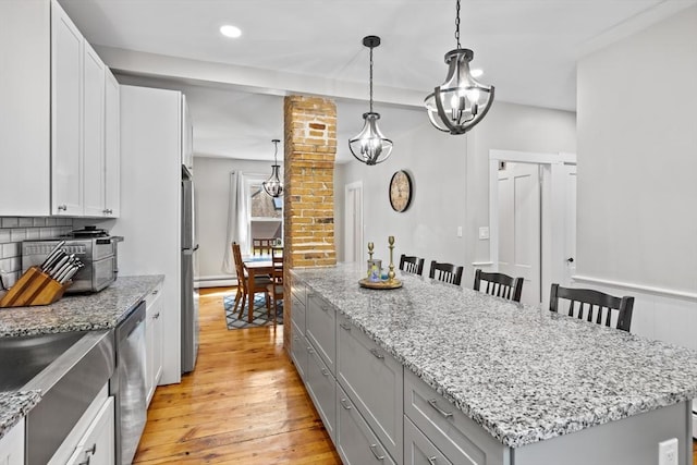 12 Russell St, Amesbury, MA 01913 - kitchen featuring a chandelier, a kitchen island, light wood-type flooring, a breakfast bar, and recessed lighting