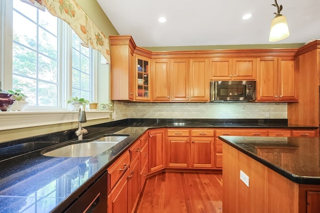 kitchen with sink, light hardwood / wood-style flooring, decorative light fixtures, and tasteful backsplash