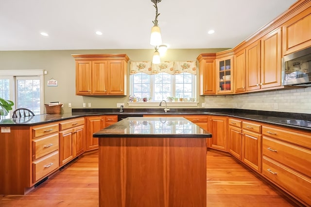 kitchen featuring light hardwood / wood-style flooring, a healthy amount of sunlight, and decorative light fixtures