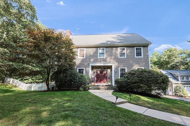 colonial inspired home with a front lawn