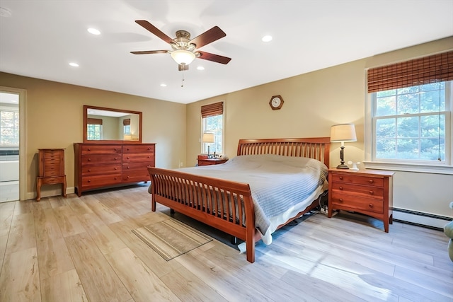 bedroom featuring a baseboard radiator, multiple windows, light hardwood / wood-style floors, and ceiling fan