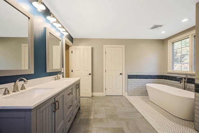 bathroom with vanity, a tub to relax in, and tile patterned floors