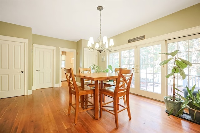 dining area featuring a notable chandelier, hardwood / wood-style flooring, and a healthy amount of sunlight