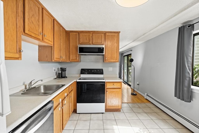 271 Humphrey St Unit H2, Lowell, MA 01850 - kitchen featuring stainless steel appliances, a baseboard heating unit, light countertops, brown cabinetry, and light tile patterned floors