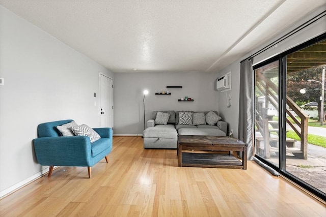 271 Humphrey St Unit H2, Lowell, MA 01850 - living area featuring light wood finished floors, a textured ceiling, and a wall unit AC