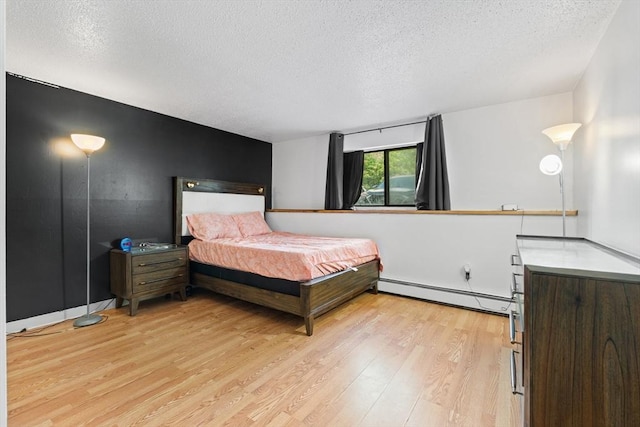 271 Humphrey St Unit H2, Lowell, MA 01850 - bedroom featuring a baseboard radiator, a textured ceiling, and light wood-style flooring