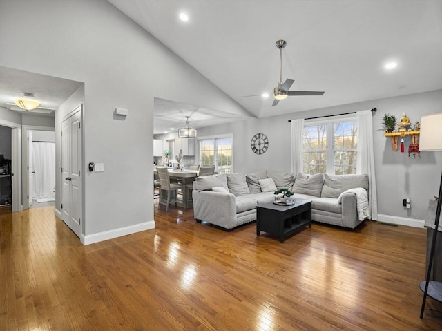 living room featuring hardwood / wood-style floors, high vaulted ceiling, and ceiling fan