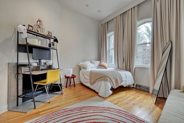 bedroom featuring multiple windows and wood finished floors