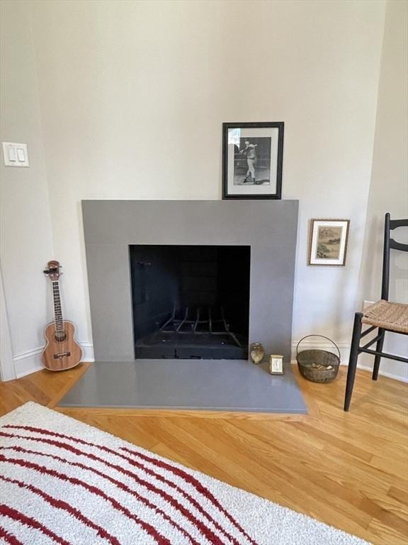 details with baseboards, a fireplace, and wood finished floors