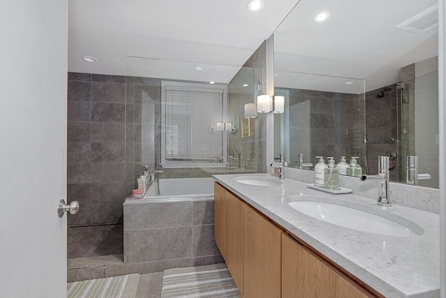 full bath featuring visible vents, a sink, recessed lighting, and a shower stall