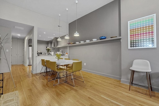 dining space with visible vents, baseboards, and wood finished floors